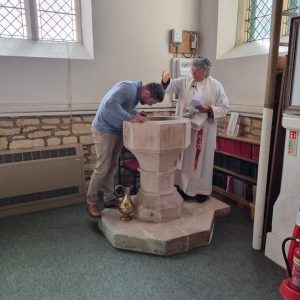 Joanne's partner Dan being baptised by Helen Hill