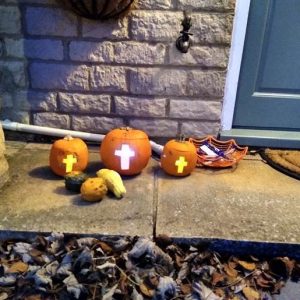 Pumpkins on a doorstep carved with crosses