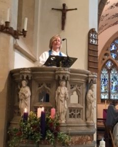 Reader Linda Jarvis preaching robed, from a pulpit