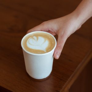A hand reaching for a coffee cup